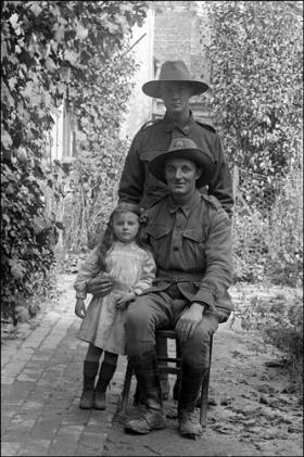Australian troops pose with a small girl