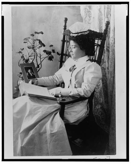 Nursing student wearing a starched white uniform, seated in a rocking chair, reading. 1900 Reproduction Number- LC-USZ62-124811